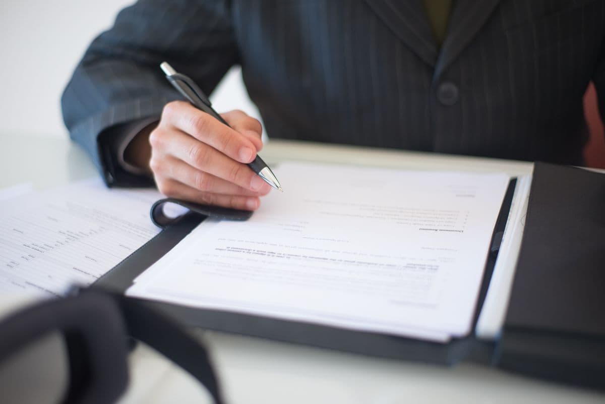 close up of signed mortgage documents with keys and calculator on a desk