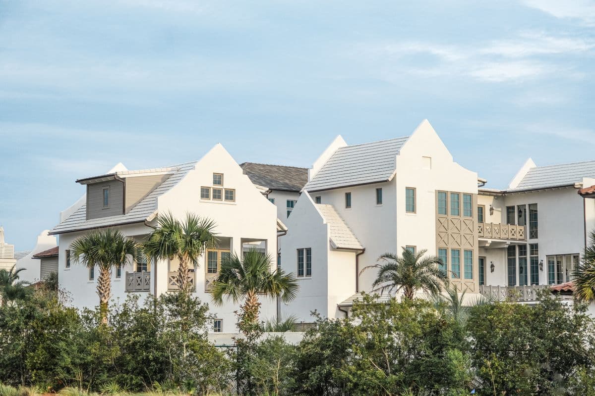 light-colored residential buildings surrounded by palm trees and landscaping