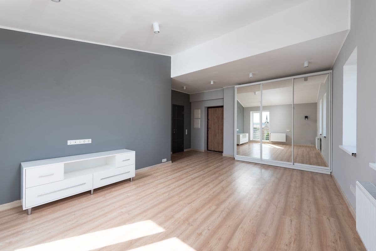 bright unfurnished room with mirrored closet doors and wood flooring