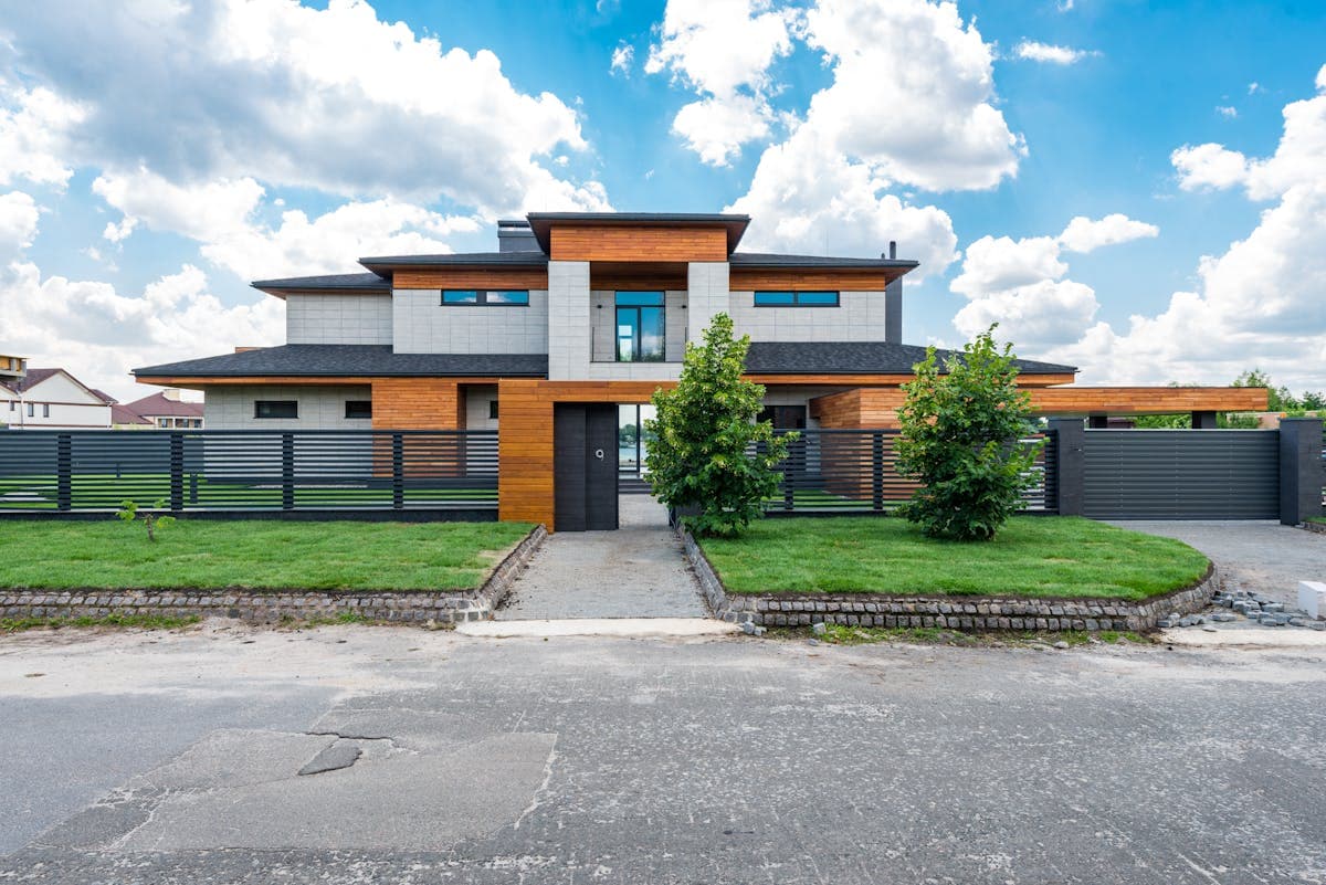 A beautiful modern home exterior with a well-manicured front yard during golden hour