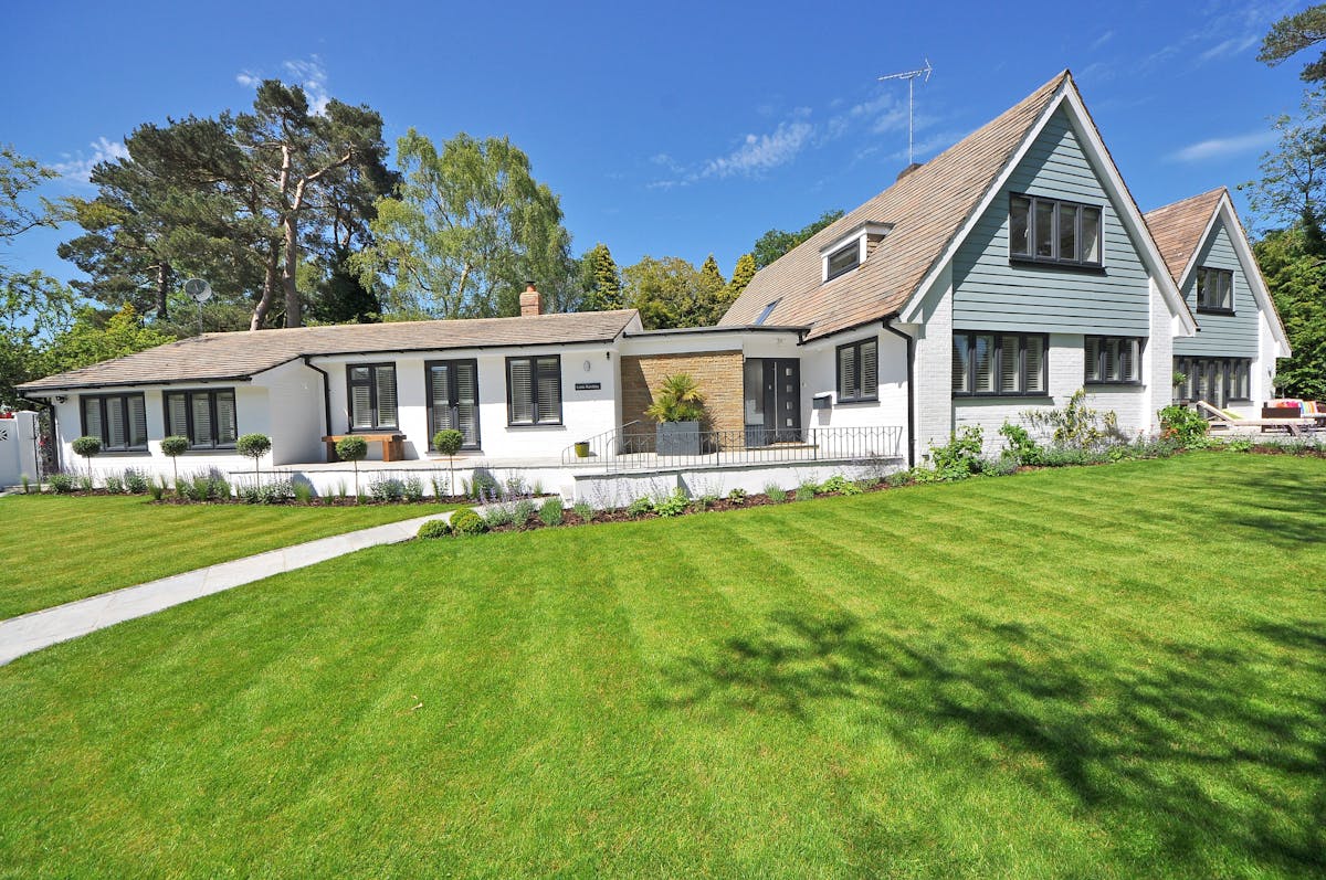 modern home exterior with green lawn and landscaped entrance