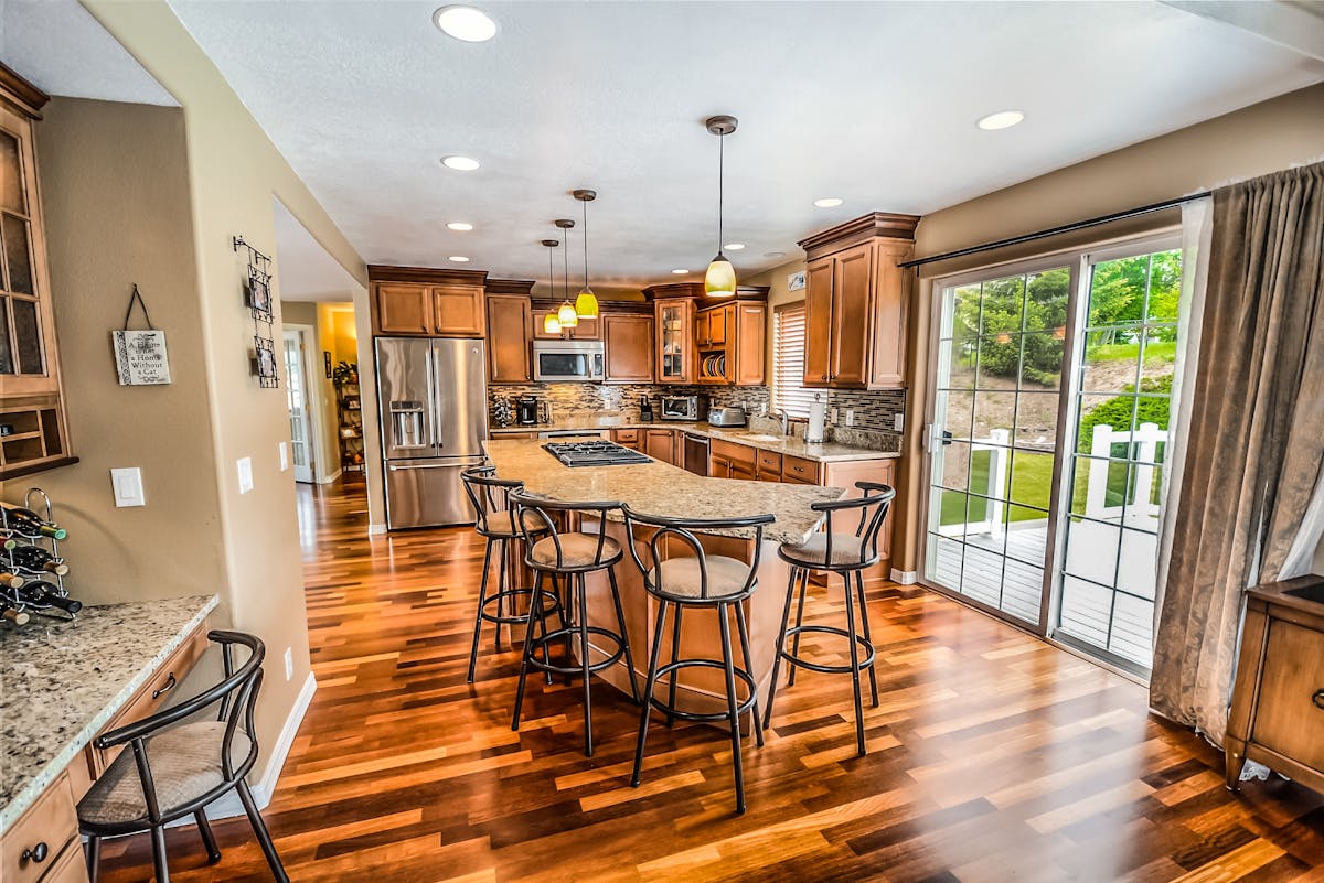bright modern kitchen with granite island and wooden cabinetry