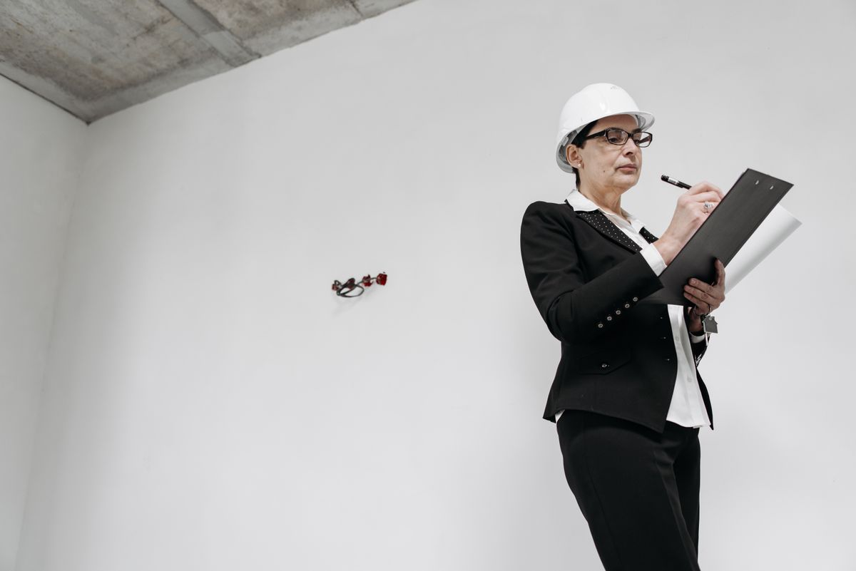 professional inspector with hard hat reviewing notes indoors