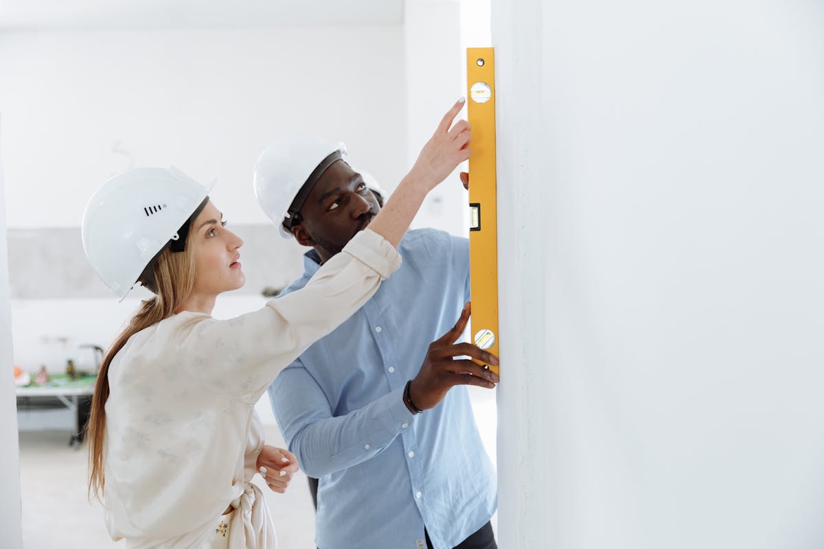 construction workers using a level tool on an indoor wall