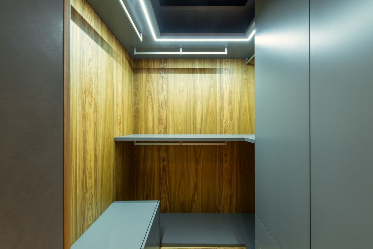 custom built-in closet with warm wood panels and empty shelves