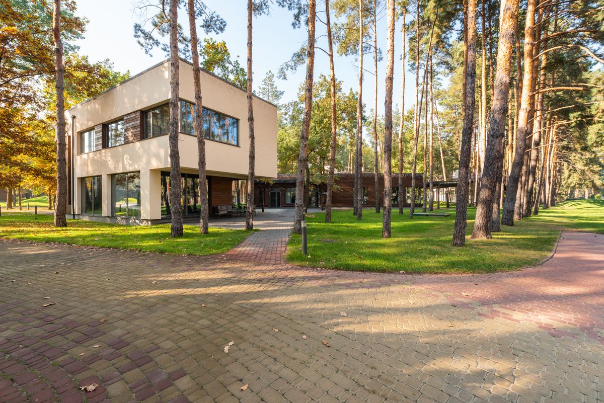 modern building in a landscaped property surrounded by tall trees