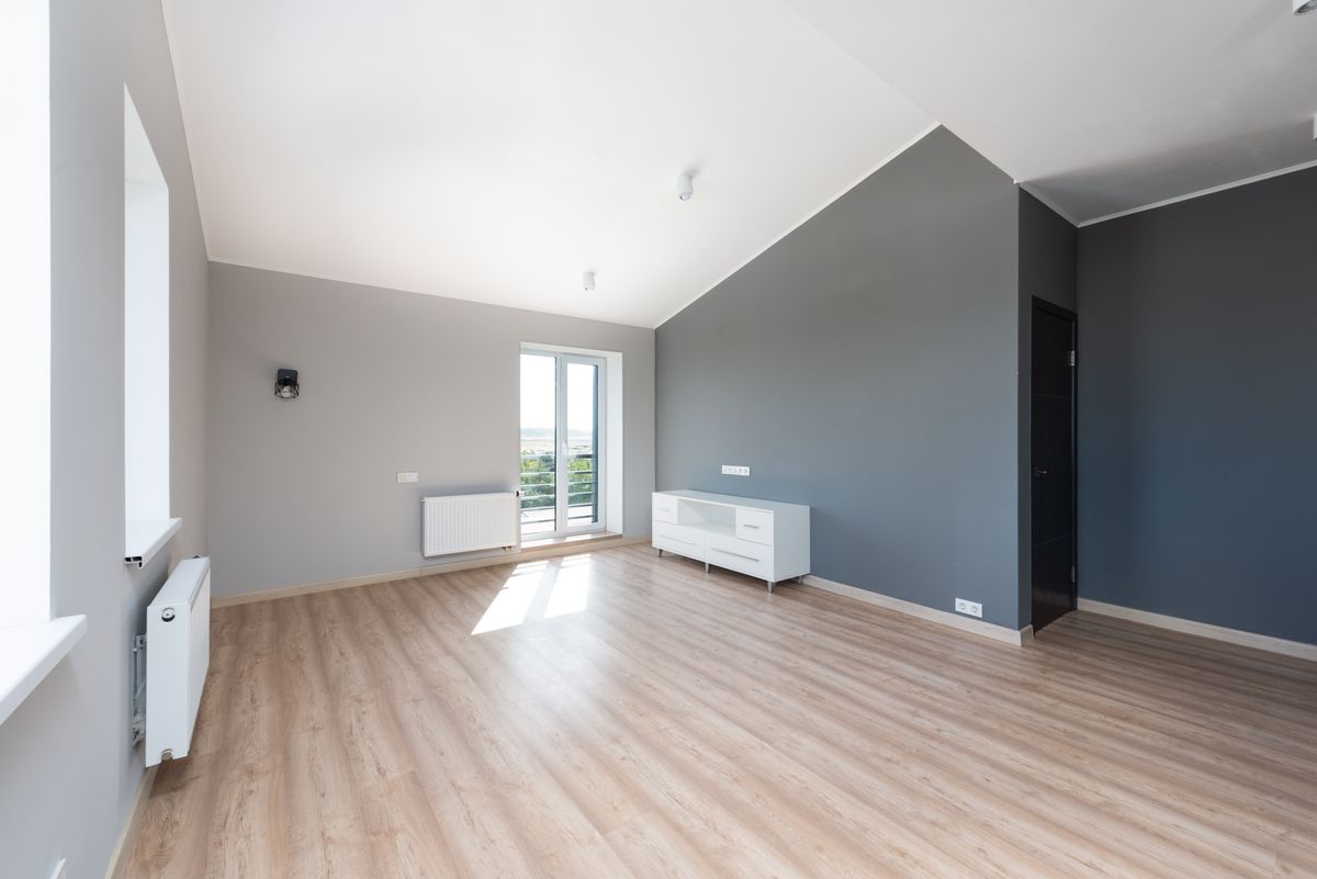 sunlit modern residential room with wood flooring and large windows