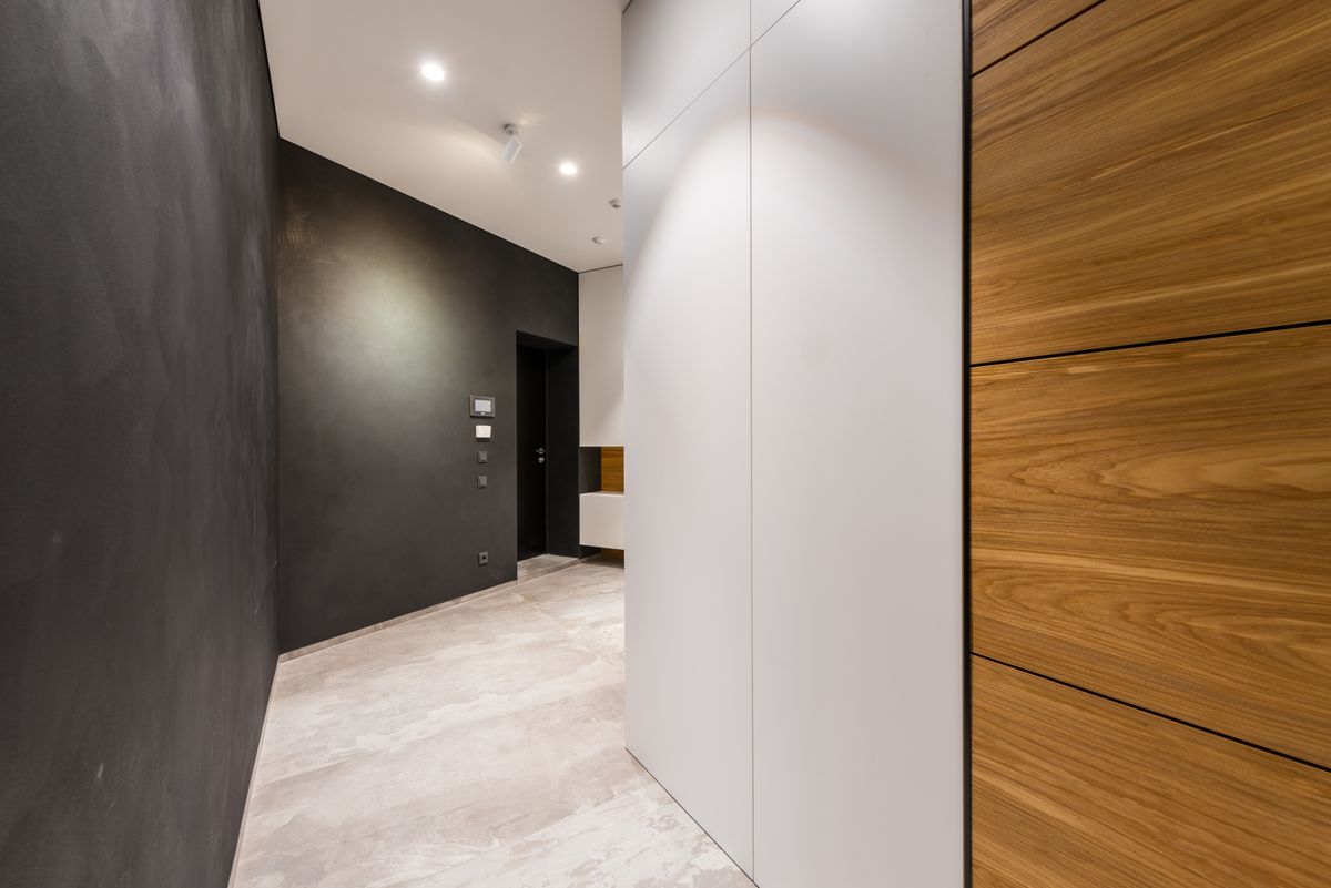 modern home hallway with dark walls and wood cabinetry